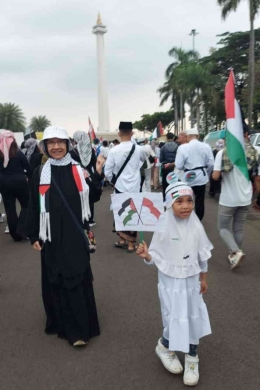 Penulis dan seorang anak yang ikut aksi solidaritas Palestina. Sumber gambar dokumen pribadi.