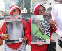 (perempuan Pangkalan Susu saat membawa poster korban diduga akibat pencemaran polusi PLTU Batubara/foto: Ahmidal Yauzar)