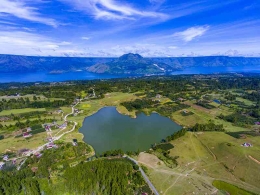Danau Sidihoni di ketinggian Pulau Samosir dengan latar belakang Danau Toba dan Gunung Pusukbuhit (Foto: calderatobageopark.org)