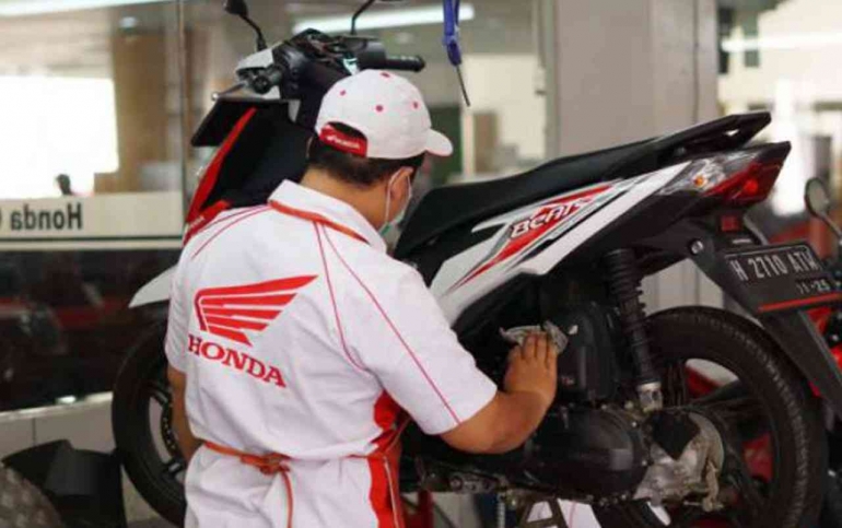 Montir bengkel AHASS sedang melakukan servis sepeda motor Honda (Foto: wahanahonda.com)