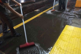 Petugas sigap membersihkan lantai peron yang basah (foto: widikurniawan)