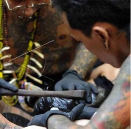 Pembuatan tato dengan sistem tok-tok khas suku Dayak (Sumber: Wilfirmus)