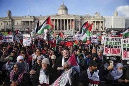 Protesters hold placards and Palestinian flags during a pro-Palestinian rally in Trafalgar Square, London, Saturday Nov. 4, 2023. (Victoria Jones/PA v)