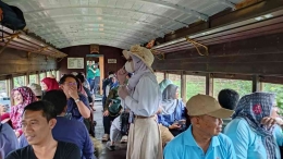 Pemandu wisata menjelaskan informasi selama perjalanan by Dani Irawan