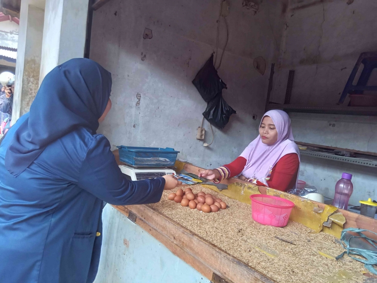 Pembagian brosur tabungan haji dan umroh kepada nasabah BPRS Amanah Ummah di Pasar Leuwiliang, Selasa (21/11/2023). (Foto Nurhayati)