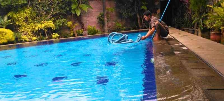 Tekhnisi jasa perawatan kolam renang sedang melakukan pekerjaan perawatan kolam renang (Foto/Gunawan)