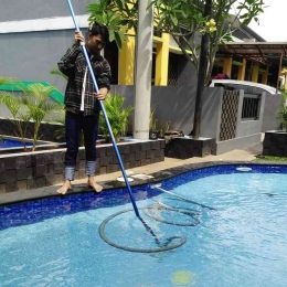 Tekhnisi melakukan pemvacuman kolam renang (Foto/Tario)