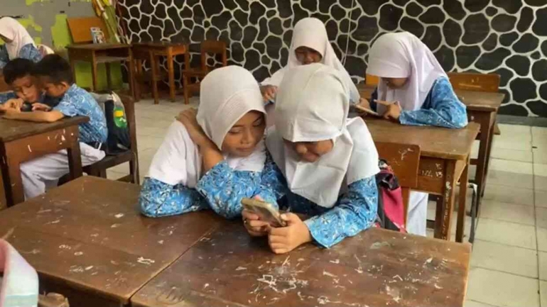 Siswa SDN 01 Petukangan Utara sedang mengerjakan kuis menggunakan HP (dokumentasi pribadi)