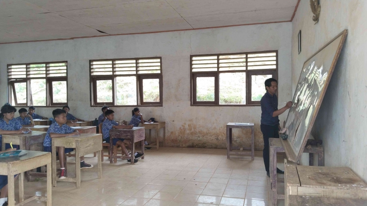 Bapak Kristian Betteng ketika mengajar di kelas pada salah satu sekolah terpencil di Tana Toraja. (Sumber: Dokumentasi Pribadi) 