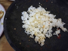 Mengeruk sisa sambal di cobek menggunakan nasi (Foto Martha Weda) 