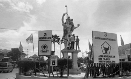 Ilustrasi - Simpatisan OPP pemilu naik ke patung Merdeka di Surabaya, Jatim, pasang gambar kampanye (2/4/1987). (Sumber: KOMPAS/AW SUBARKAH)