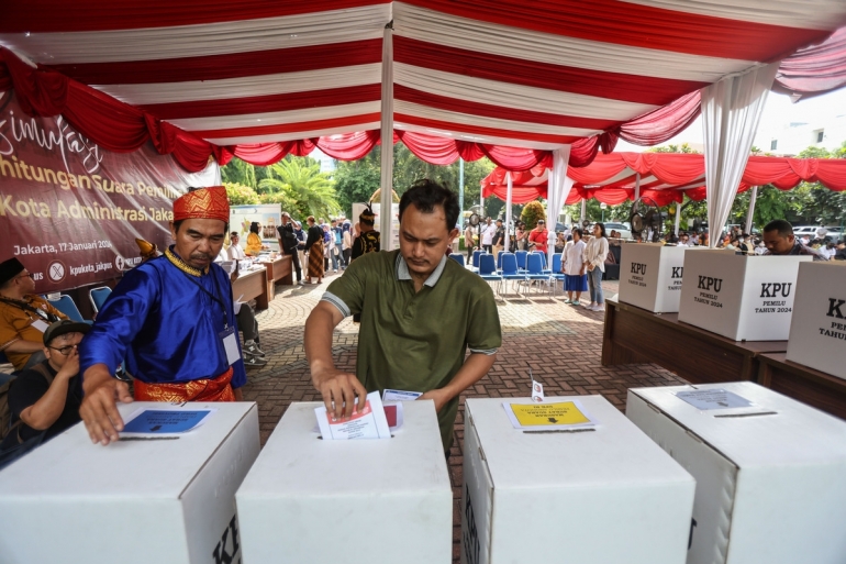 Panitia Pemungutan Suara (PPS) membantu pemilih untuk memasukkan surat suara saat simulasi pemungutan suara Pemilu 2024 di halaman Kantor Wali Kota Jakarta Pusat, Rabu (17/1/2024). Foto: KOMPAS/FAKHRI FADLURROHMAN 