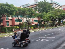 Dua orang kakek bercanda di atas scooter khusus lansia , menyeberang jalan mnuju rumah jompo atau panti wreda di Bedok, Singapura. (dokumentasi pribadi)
