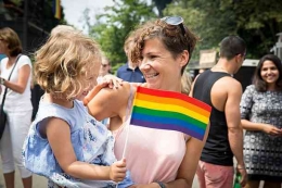 Seorang ibu menggendong anaknya dalam sebuah parade Amsterdam Pride ( istockphoto.com)