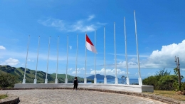 Deretan tiang untuk bendera dengan latar belakang bukit dan pantai (Foto: Theodolfi)