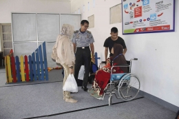 Petugas Lapas Memfasilitasi Pengunjung Lansia Menggunakan Kursi Roda Memasuki Area Kunjungan. Doc. Humas Lapas Bengkulu