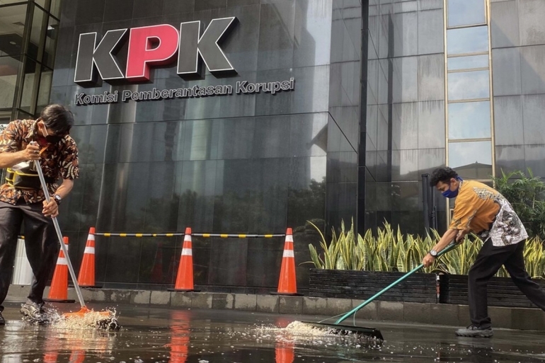 Petugas kebersihan membersihkan jalan masuk ke Gedung Komisi Pemberantasan Korupsi (KPK) di Kuningan, Jakarta, dari genangan air hujan, Jumat (22/5/2020). Foto: KOMPAS/WAWAN H PRABOWO