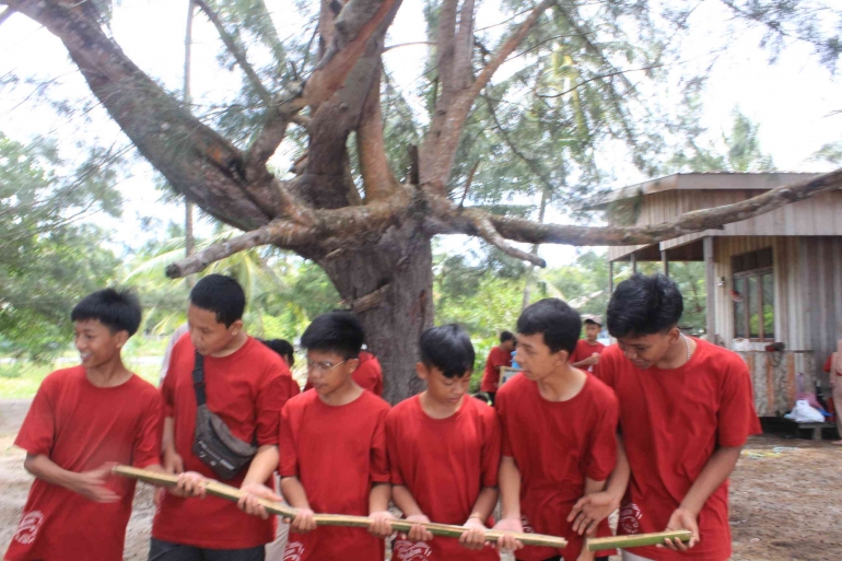 Siswa-siswi ketika bermain games estafet kelereng di Pantai Keraya. Sumber: SMP Indah Makmur.