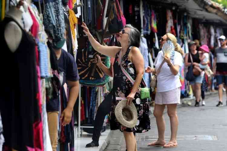 Turis asing berbelanja oleh-oleh di Bali pada Sabtu, 12 November 2022. (AP via VOA Indonesia)/travel.kompas.com