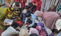 Sejumlah anak berburu tanda tangan usai salat tarawih di Masjid Nurul Falah, Kabupaten Takalar, Rabu (22/03/2023) | MAMAN SUKIRMAN via sindomakassar.com