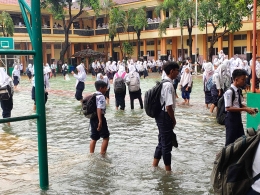 Ilustrasi 1: Siswa sepulang sekolah sedang pesta hujan di halaman sekolah yang 