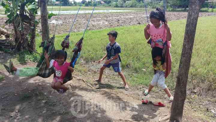 Ilustrasi kegiatan ngabuburit anak zaman doeloe dengan bermain ayunan di pohon (Sumber: tribunnews.com)