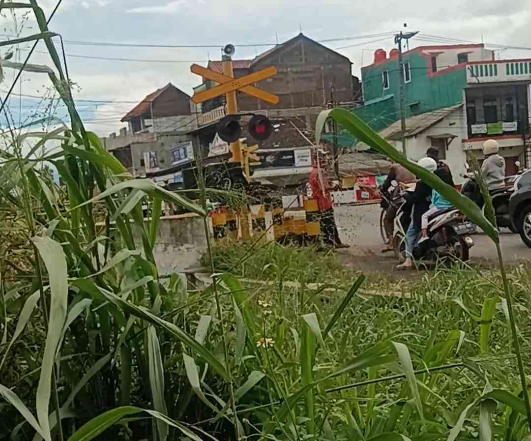 Menunggu kereta api lewat dekat palang pintu. Foto: Irma Tri Handayani