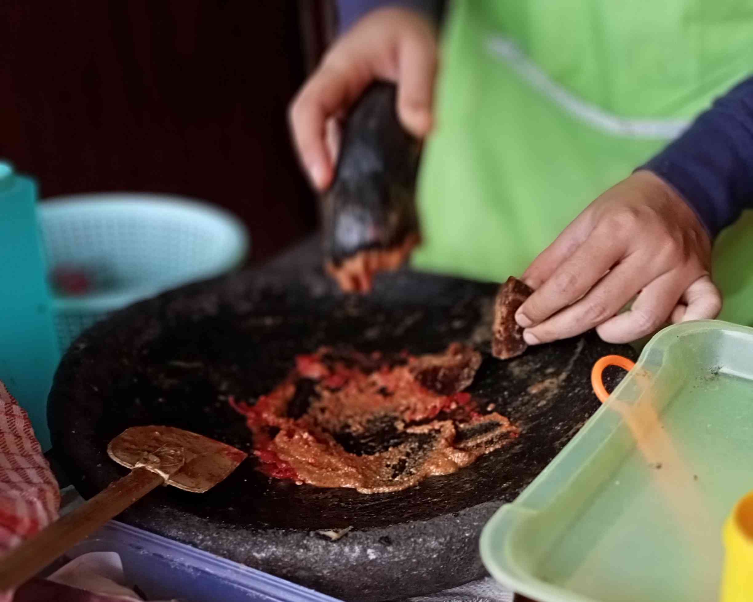 Pedagang kecil: penjual gado-gado sedang mengulek (dokumen pribadi)