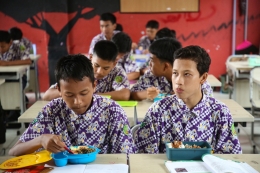 Siswa menikmati makan siang pada kegiatan simulasi program makan siang gratis di SMP Negeri 2 Curug, Kabupaten Tangerang, Banten, Kamis (29/2/2024). Foto: KOMPAS/PRIYOMBODO