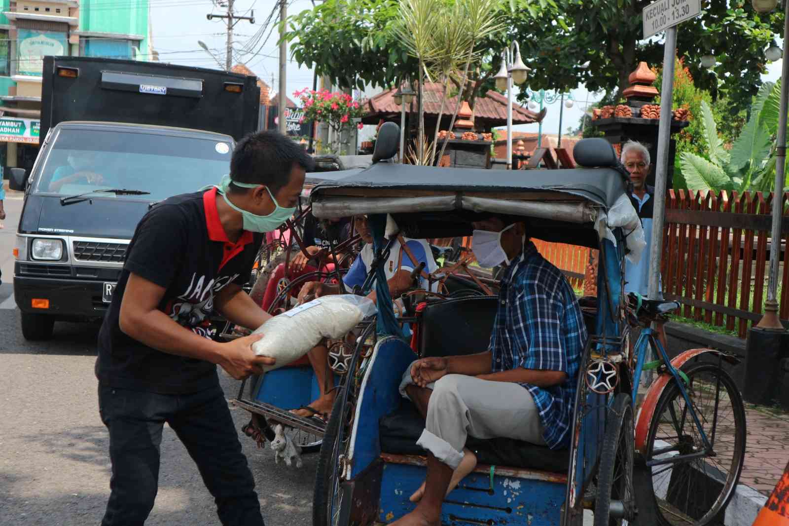 Tukang becak menerima sedekah dari seorang dermawan/Foto: Lilian Kiki Triwulan