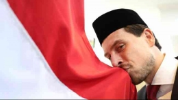 Thom Haye mencium bendera Merah Putih setelah resmi mengambil sumpah menjadi WNI, Senin (18/3/2024). (Sumber: PSSI) via kompas.tv