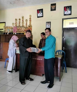 Sekbid Mental Spritual PGRI Kota Banjar, Ust. Supriyadi menyerahkan mushaf Qur'an kepada Sekbid Mental Cabang Banjar, H. Syamsi.