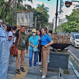 Seorang Pemandu Wisata menjelaskan sejarah Kota Bandung pada suatu kegiatan walking tour. (Dok. Pribadi)