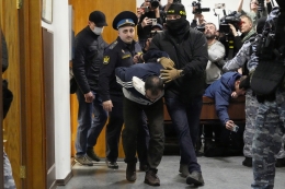 Saidakrami Murodali Rachabalizoda, tersangka penembakan Balai Kota Crocus pada Jumat, dikawal polisi dan petugas FSB di Pengadilan Distrik Basmanny di Moskwa, Rusia, Minggu (24/04/2024). Foto: AP/ALEXANDER ZEMLIANICHENKO via KOMPAS.id 