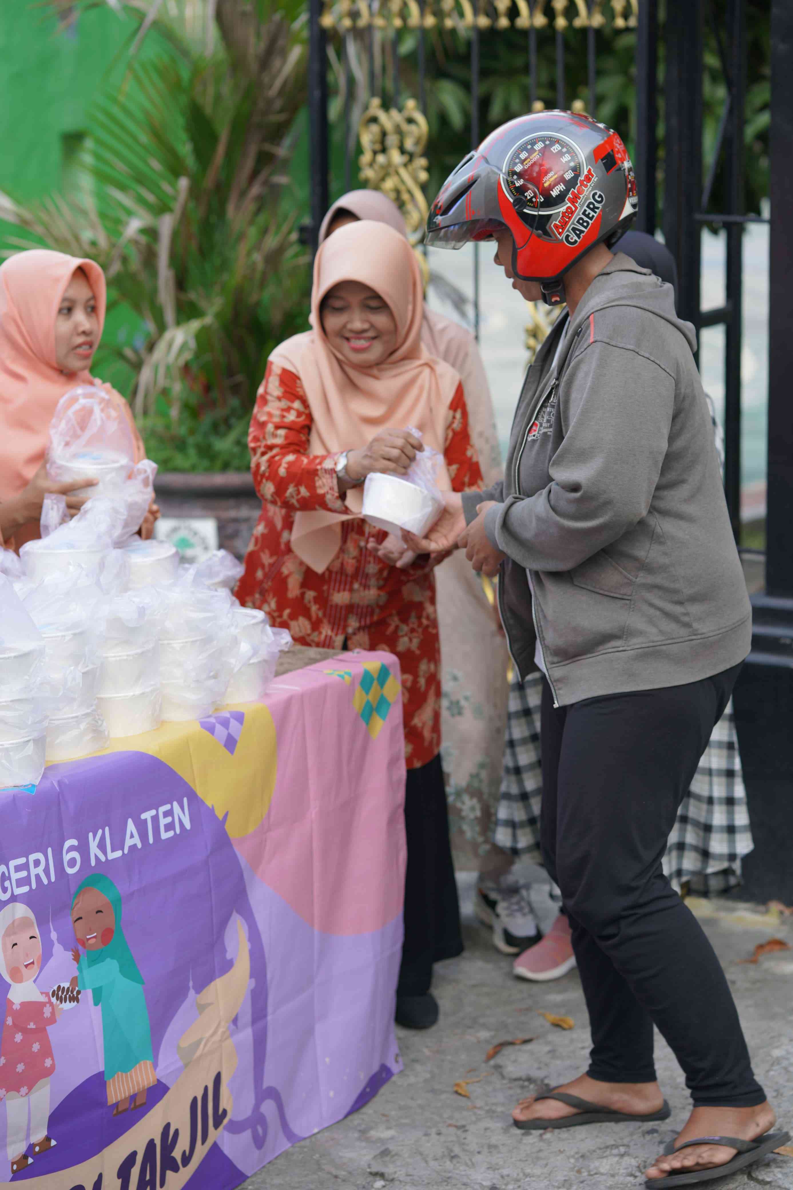 Ibu ketu Dharma Wanita, Esemku Manis, Dra. Sri Haryanti membagikan takjil buka puasa kepada warga yang lmembutuhkan. (Foto:Dok/Diq)