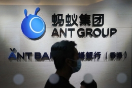 Pekerja berjalan di depan logo Ant Group di kantor perusahaan ini, di Hong Kong. AP PHOTO/KIN CHEUNG via KOMPAS.id