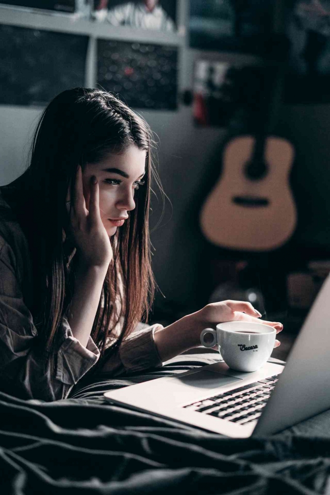 https://www.pexels.com/photo/photo-of-woman-lying-on-bed-while-using-laptop-4066041/