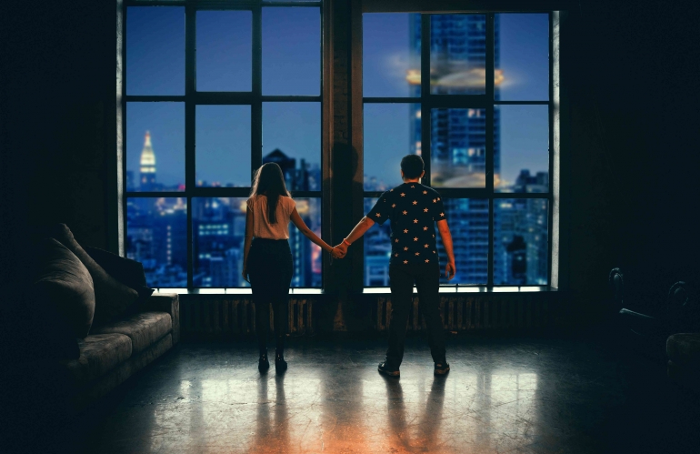 Sumber : Unsplash_Man and Woman-Holding-Hands- In-front-of- glass-window