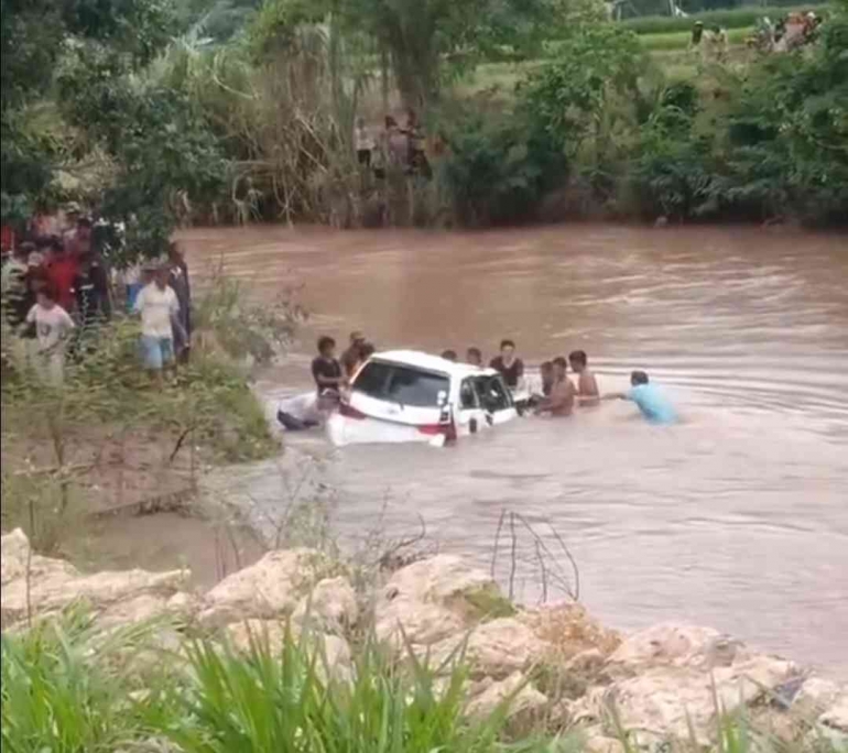 Warga mengevakuasi sebuah mobil yang terjun ke sungai. Sumber: Lusiana Remak