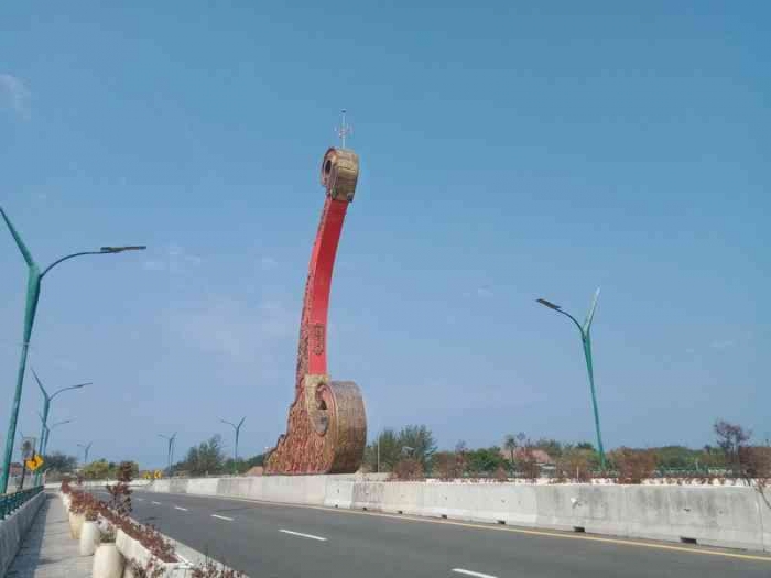 Tugu berwujud luku yang membelah sawah dan jalur hijau yang kering. | Dokumen pribadi