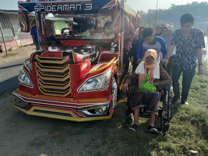 Ibunda diturunkan dari sepur mini ganti naik kursi roda (dokpri)