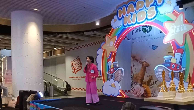 Lowkey menyanyikan lagu di atas panggung dengan penerangan yang lembut