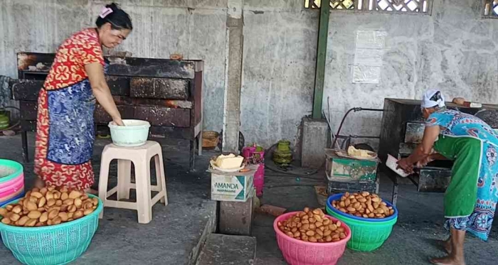 Karyawan bolu Magetan sedang memanggang dan mengangkat bolu yang sudah matang (dokpri)