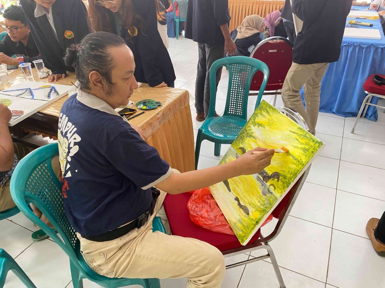 Proses melukis oleh salah satu kelompok sasaran pada program pojok literasi melukis di Kantor Kecamatan Pribadi, sumber: dokumentasi pribadi