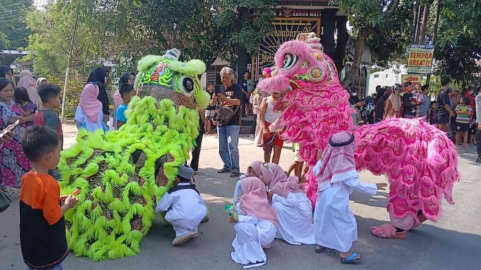 Santriwan dan santriwati penasaran melihat apa yang ada di balik kostum barongsai. Hihihi (dokpri)