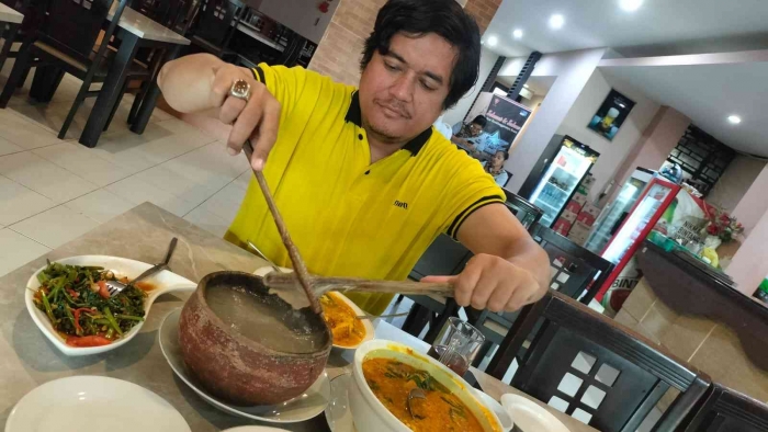 (Own photo) Pak Horas is enjoying his first papeda and yellow fish sauce in Ambon