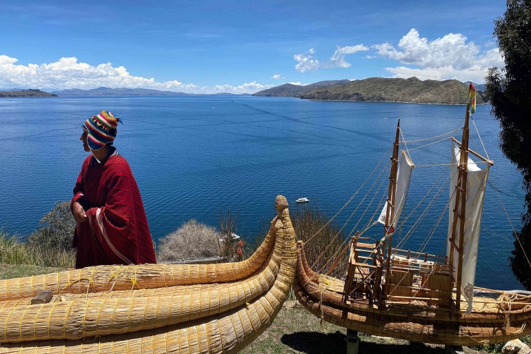 An Aymara man next to a boat made from totora at Lake Titicaca. (EEJCC)