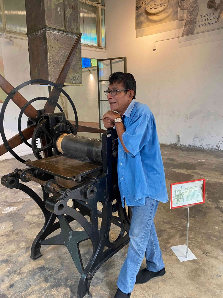 Penulis berpose dgn mesin cetak uang tempo doeloe di Blok M, Jaksel. Foto : Kenia Pakpahan.
