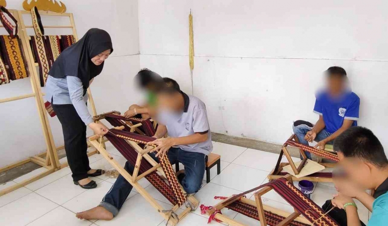 Petugas melakukan pengecekan terhadap produk kain tapis karya Warga Binaan Lapas Metro. (Sumber: Humas Lapas Metro)