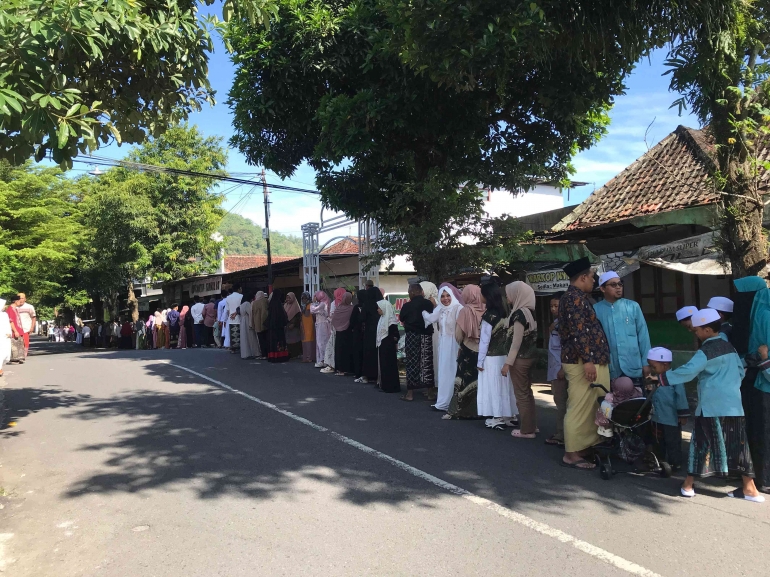 Warga dan pemuda berbaris untuk melakukan sungkeman dan saling berjabat tangan di sepanjang jalan | Sumber : Dokumen Pribadi Penulis